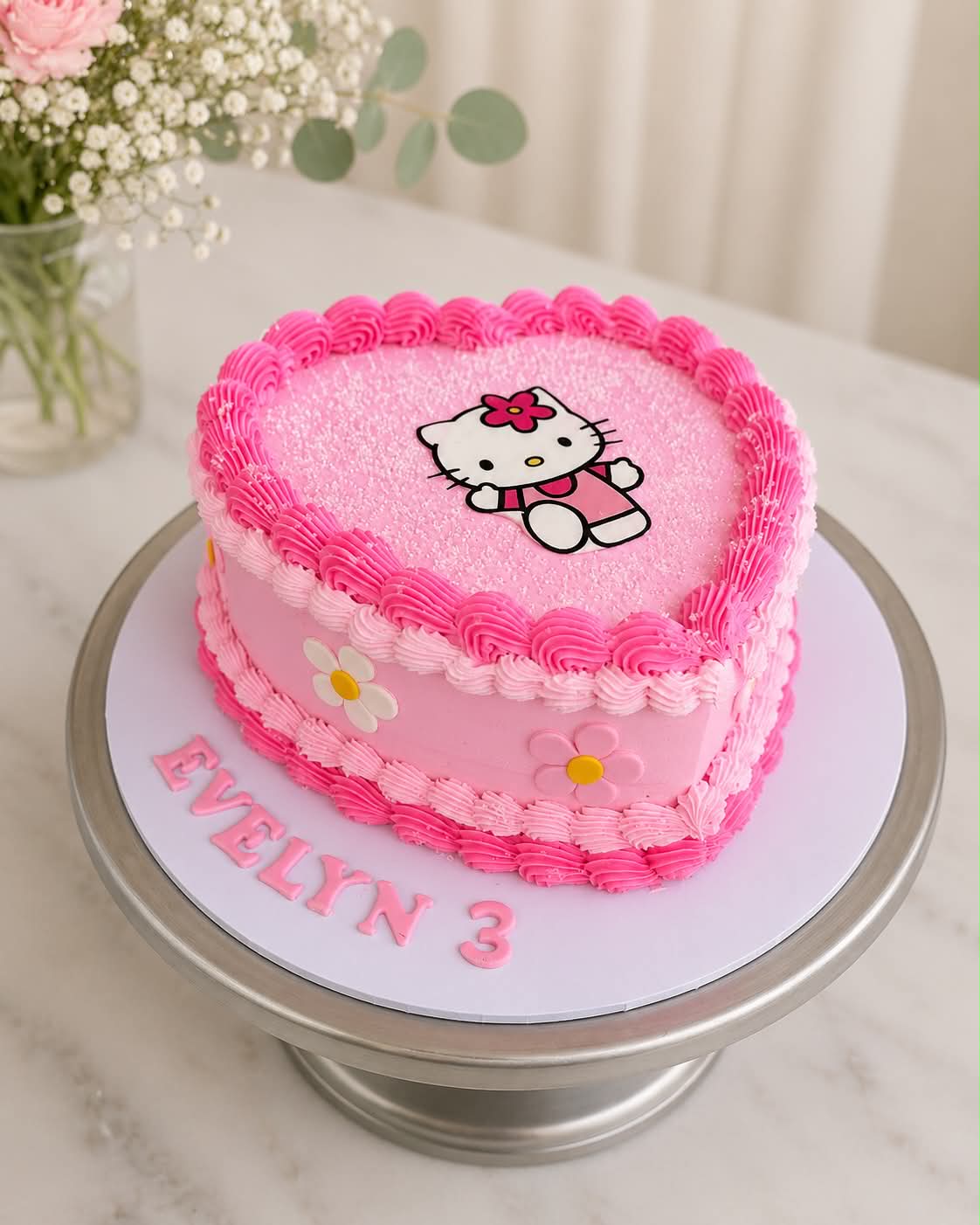 Pink Hello Kitty heart cake with daisy decorations for Evelyn 3rd birthday